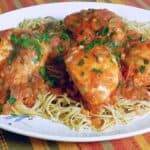 Chicken covered with vinegar tomato sauce over a bed of noodles.