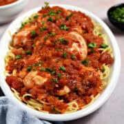 Tomato vinegar chicken and spaghetti on an oval serving platter.