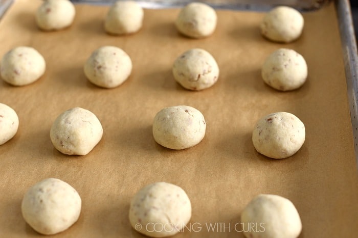 Fifteen baked cookies on a parchment lined baking sheet.