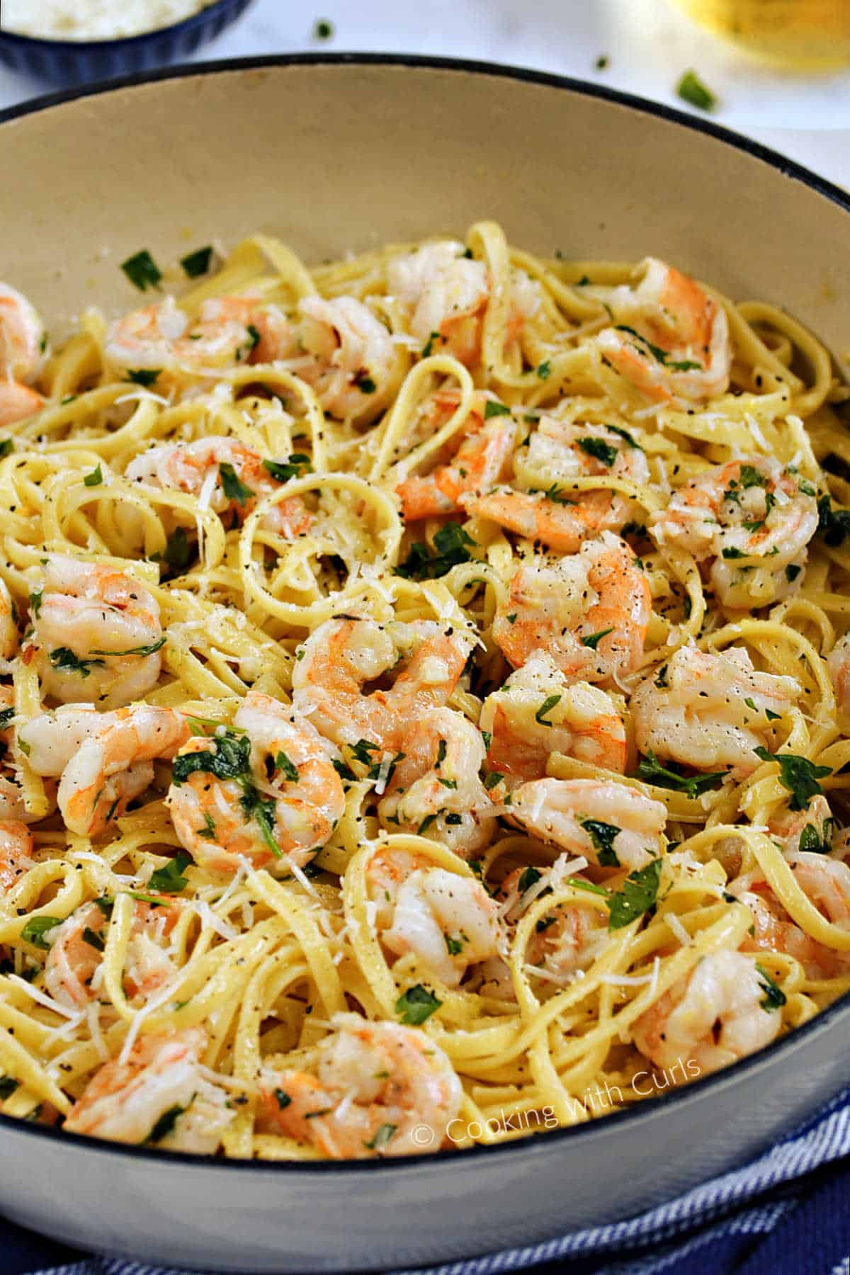 Shrimp and linguine pasta tossed with garlic, lemon, and wine sauce in a large skillet.