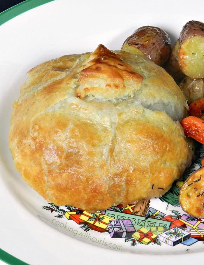 close up of beef wellington on a Christmas plate with roasted vegetables