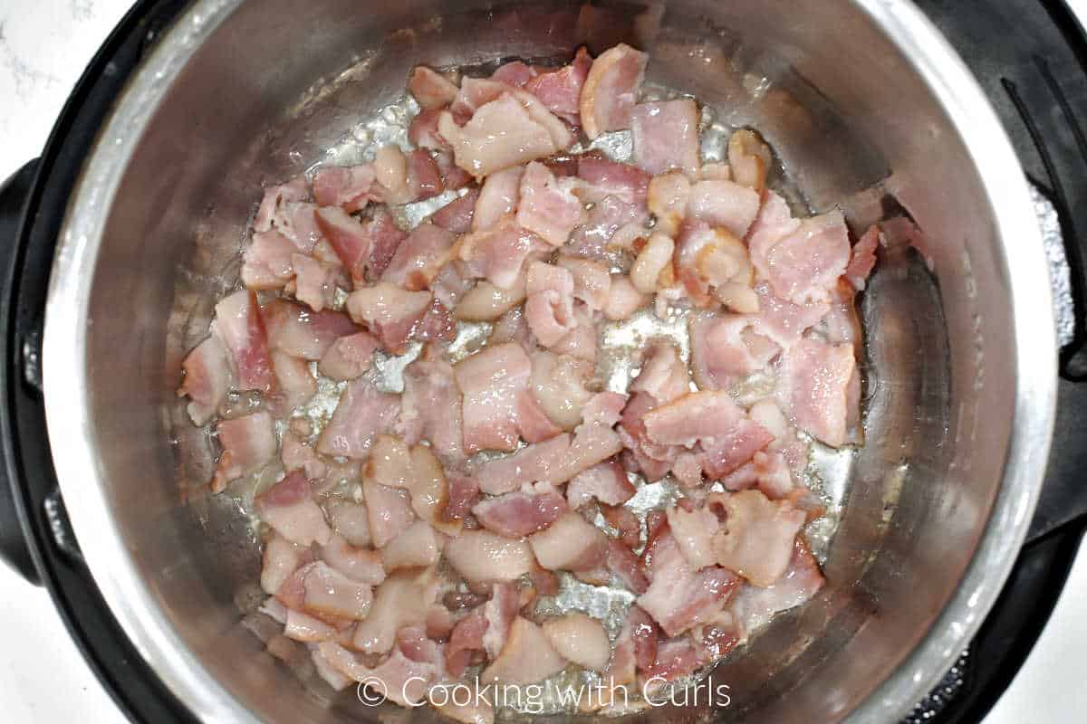 Bacon pieces sautéed in a pressure cooker. 