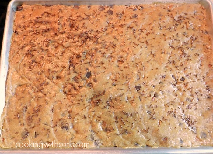 Blonde brownie dough spread out in a baking sheet. 