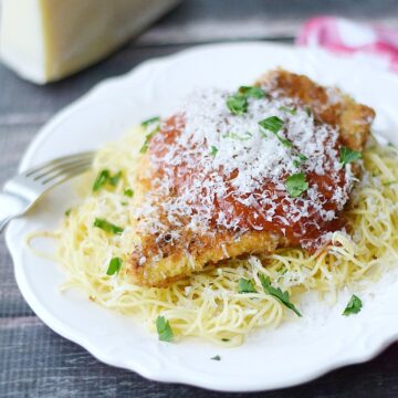 Chicken Parmesan served on a bed of of pasta | cookingwithcurls.com