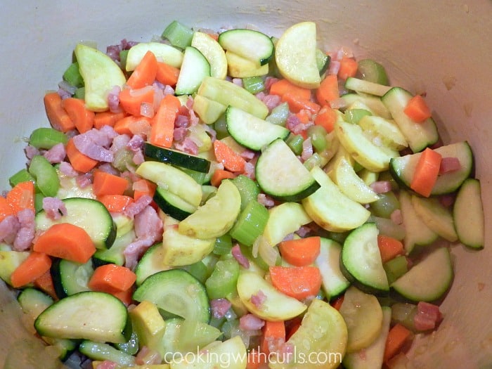 Chopped vegetables stirred into the pancetta in a large pot. 