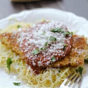 Crispy panko crusted chicken parmesan on a bed of angel hair pasta and topped with marinara sauce and grated parmesan.
