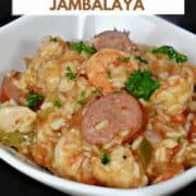 Shrimp Jambalaya with sliced sausage and chicken with rice in a bowl with title graphic across the top.