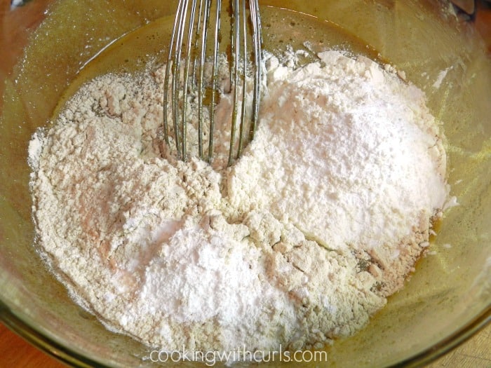 Flour whisked into the melted butter and sugar mixture in a large glass bowl. 