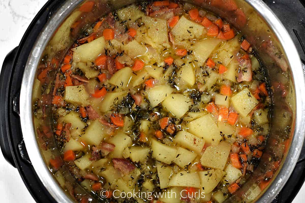 Potatoes, carrots, spices, and bacon cooked in clam juice in a pressure cooker. 