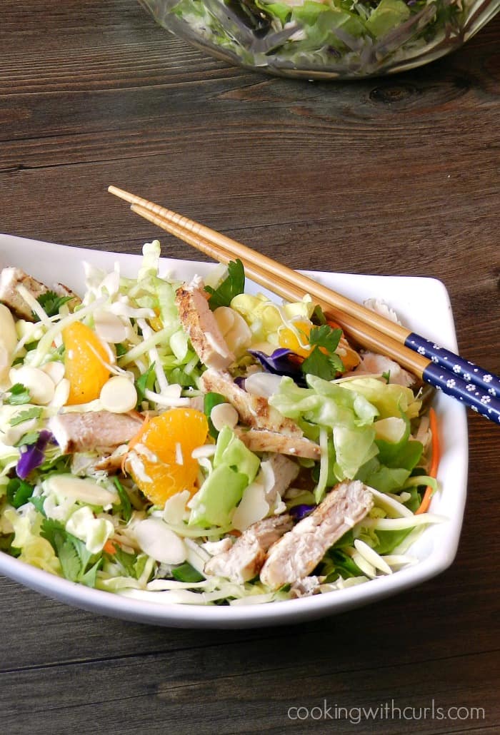 Asian Chicken Salad in a white, rectangle bowl with chop sticks in the upper right hand corner