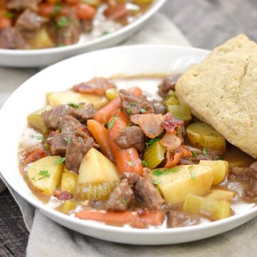 A big white bowl of Beef Stew with Guinness Biscuits sitting on a beige napkin