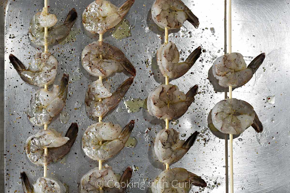 skewered-shrimp-with-olive-oil-and-seasoning-on-a-baking-sheet.
