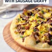 Breakfast Pizza with Sausage Gravy, scrambled eggs and bacon on a puffy pizza crust with title graphic across the top.