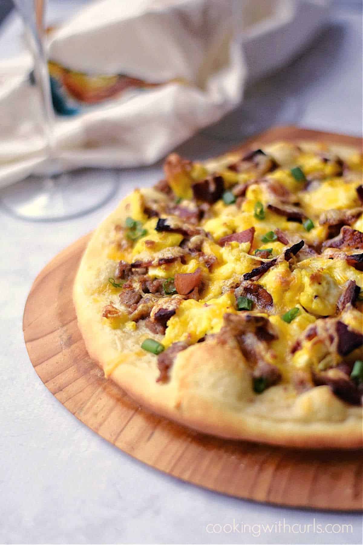 Breakfast Pizza with Sausage Gravy, scrambled eggs and bacon on a homemade pizza crust.