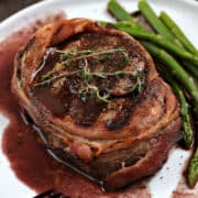 Bacon Wrapped Filet Mignon with Red Wine Sauce and asparagus spears.