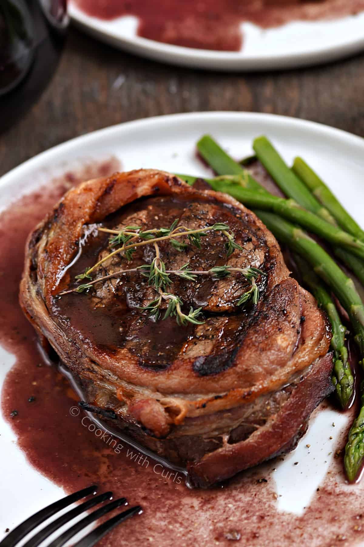 Bacon Wrapped Filet Mignon with Red Wine Sauce and asparagus spears. 