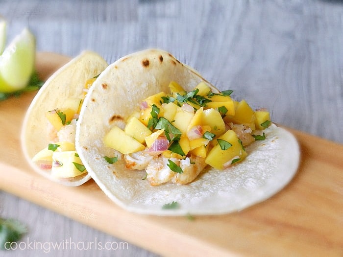 Baked Fish Tacos with Papaya Mango Salsa sitting on a wooden cutting board