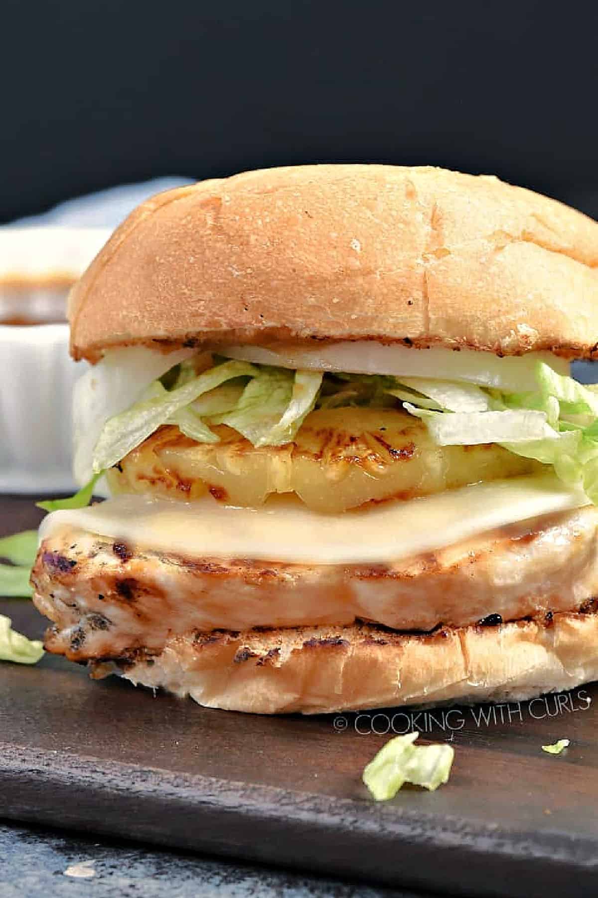 Grilled chicken breast topped with melted white cheese, grilled pineapple slice, lettuce, onion and bun.