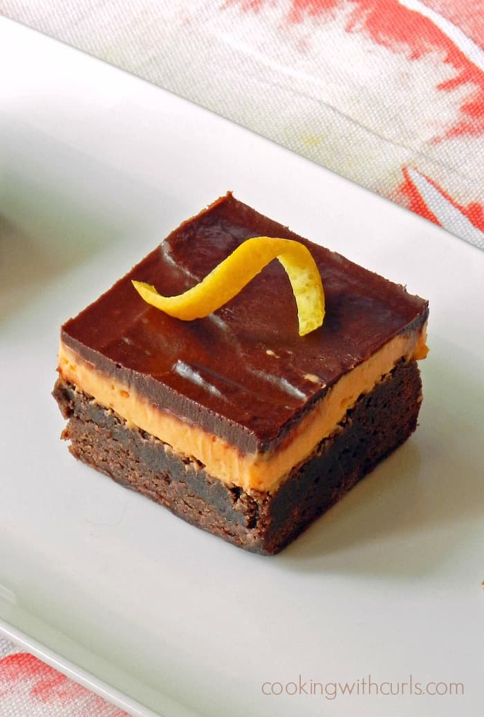 Orange Boozy Brownies are not your average brownies! They consist of a brownie base with an orange liqueur filling and are covered with chocolate topping. cookingwithcurls.com