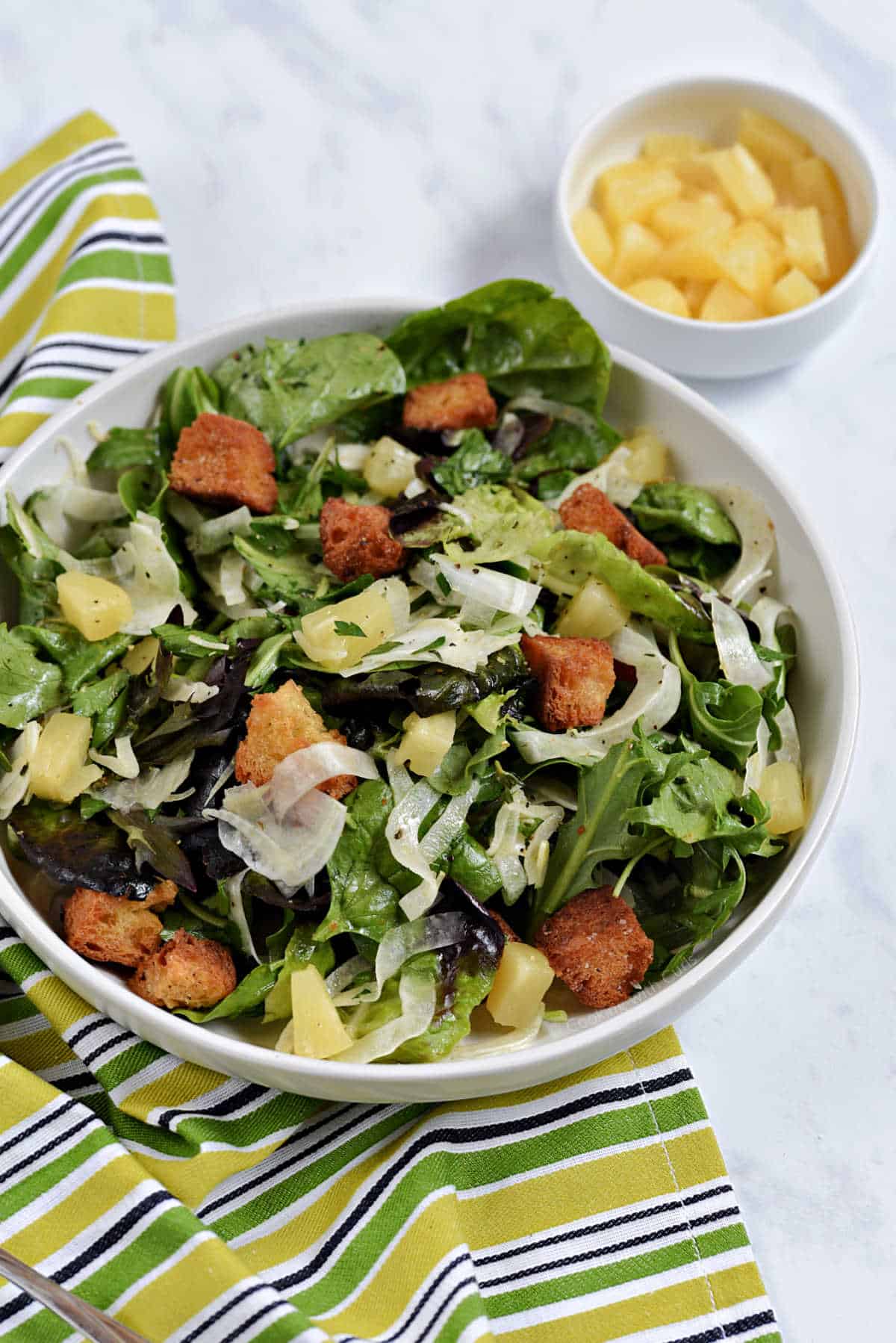 Shaved fennel salad with mixed greens, pineapple chunks and croutons.