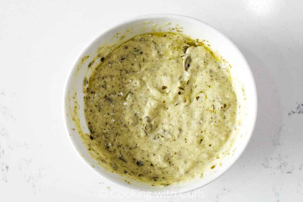 Pesto mixed with mayonnaise in a small bowl.