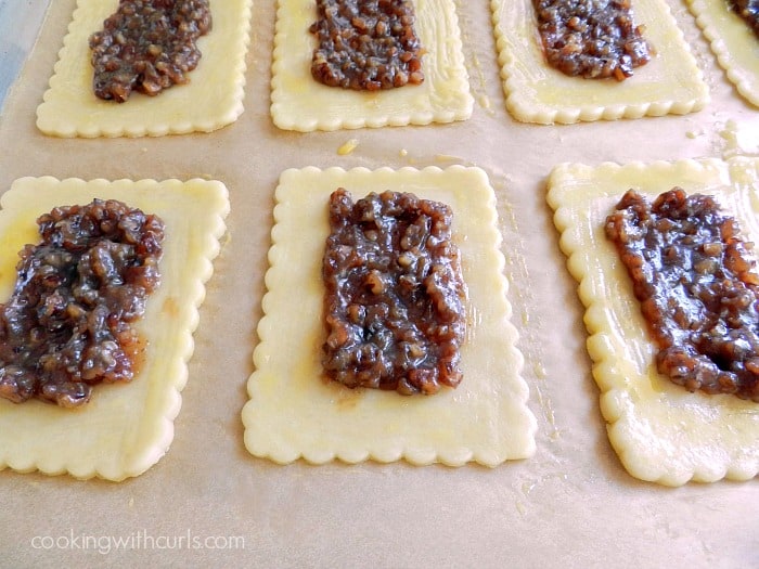 Pop tart filling in the center of seven pastry rectangles that have been brushed around the edges with egg. 