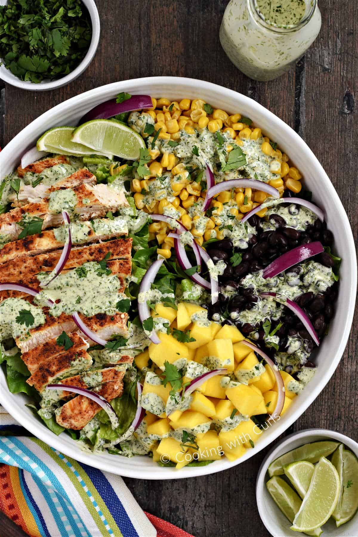 Southwest Chicken Salad with corn, black beans, mango chunks, and red onion slices topped with creamy cilantro lime dressing.