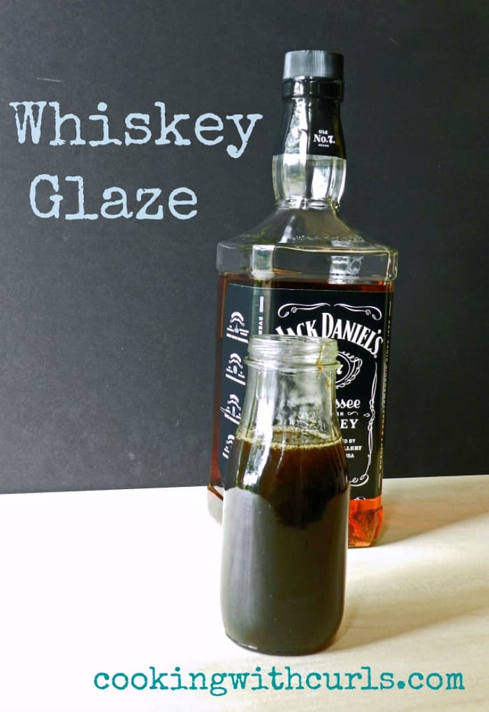 whiskey glaze in a glass bottle sitting in front of a bottle of Jack Daniels