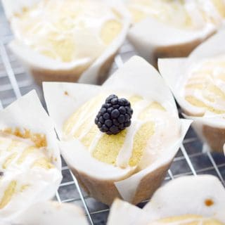 Blackberry Muffins with Lemon Glaze in tulip paper liners on a wire rack
