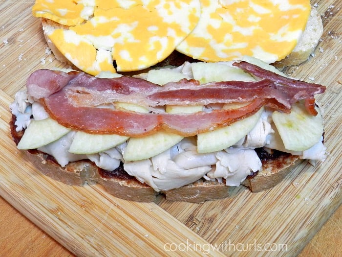 Turkey, apple, bacon and cheese slices on sourdough bread.