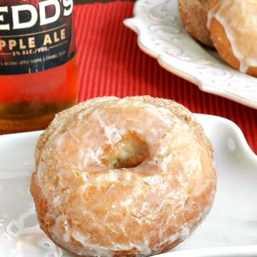 apple ale doughnuts sitting on white plate with a bottle of apple ale in the background