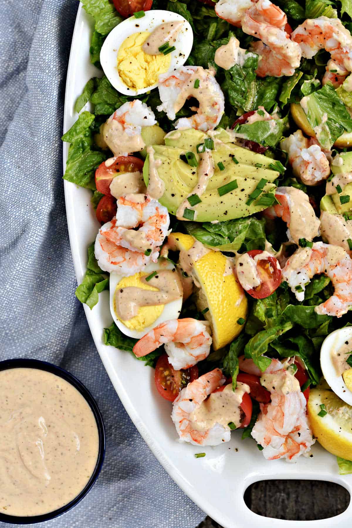Thousand island dressing in a small bowl and drizzled over a shrimp salad.