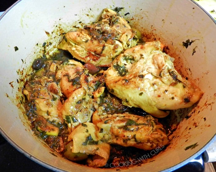 Cooked chicken added back into the sauce in the Dutch oven