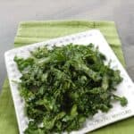 Kale Chips on a white plate sitting on a green towel