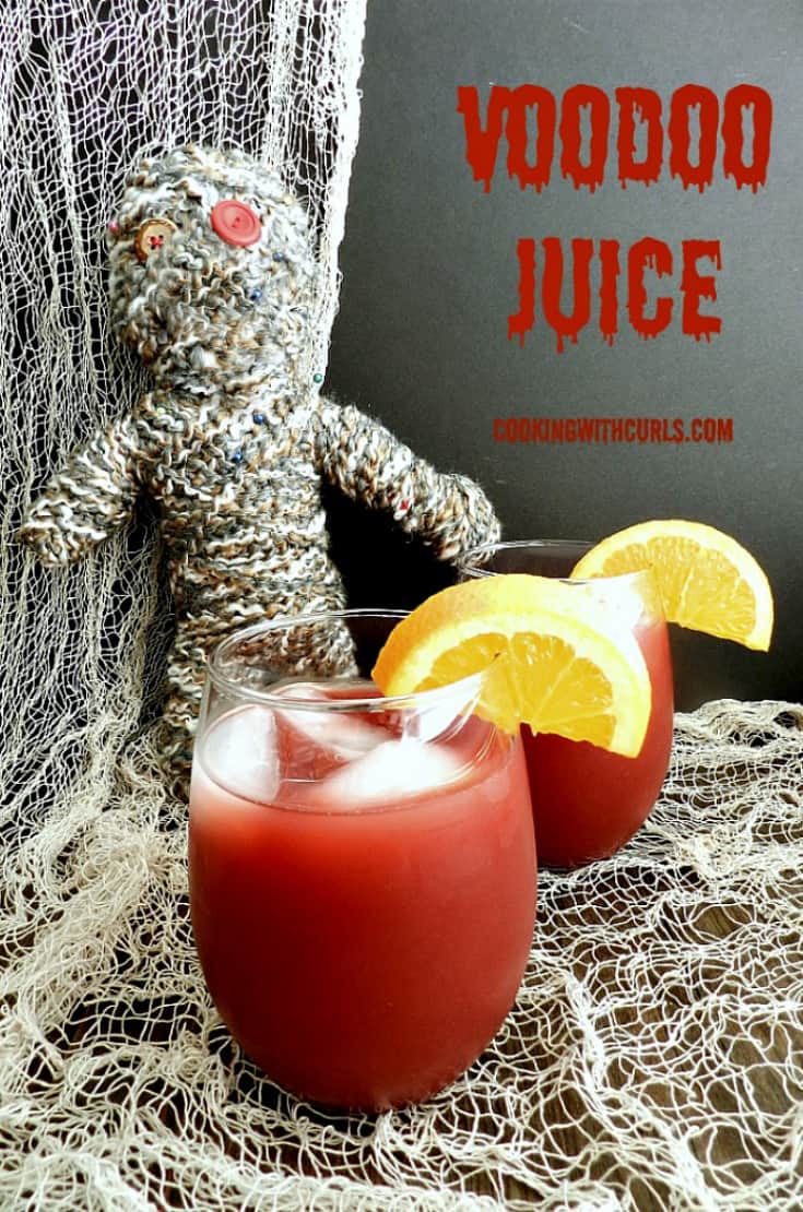 Two glasses of Voodoo Juice sitting in front of a voodoo doll and surrounded by netting