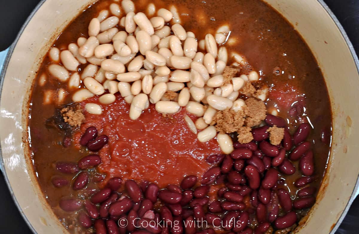 White and red kidney beans, crushed tomatoes, and whiskey added to the ground beef mixture in a large pot. 