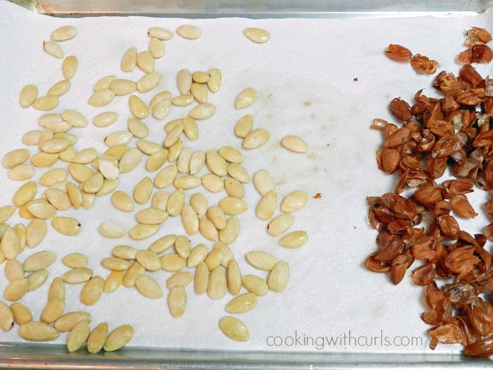 blanched almonds on a paper towel lined baking sheet