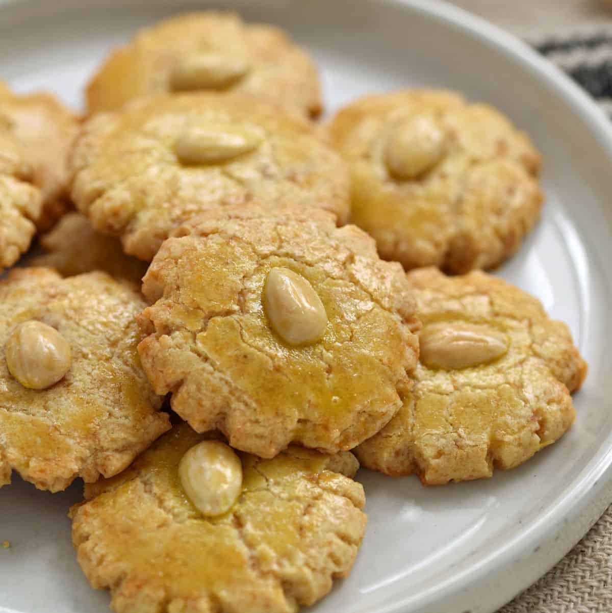 Ten Chinese Almond Cookies stacked on a white plate.