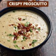 Creamy cauliflower soup topped with crumbled, crispy prosciutto and chopped parsley with title graphic across the top.