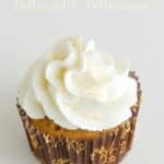 cupcake topped with white frosting and gold glitter wrapped in a brown and gold scroll patterned wrapper