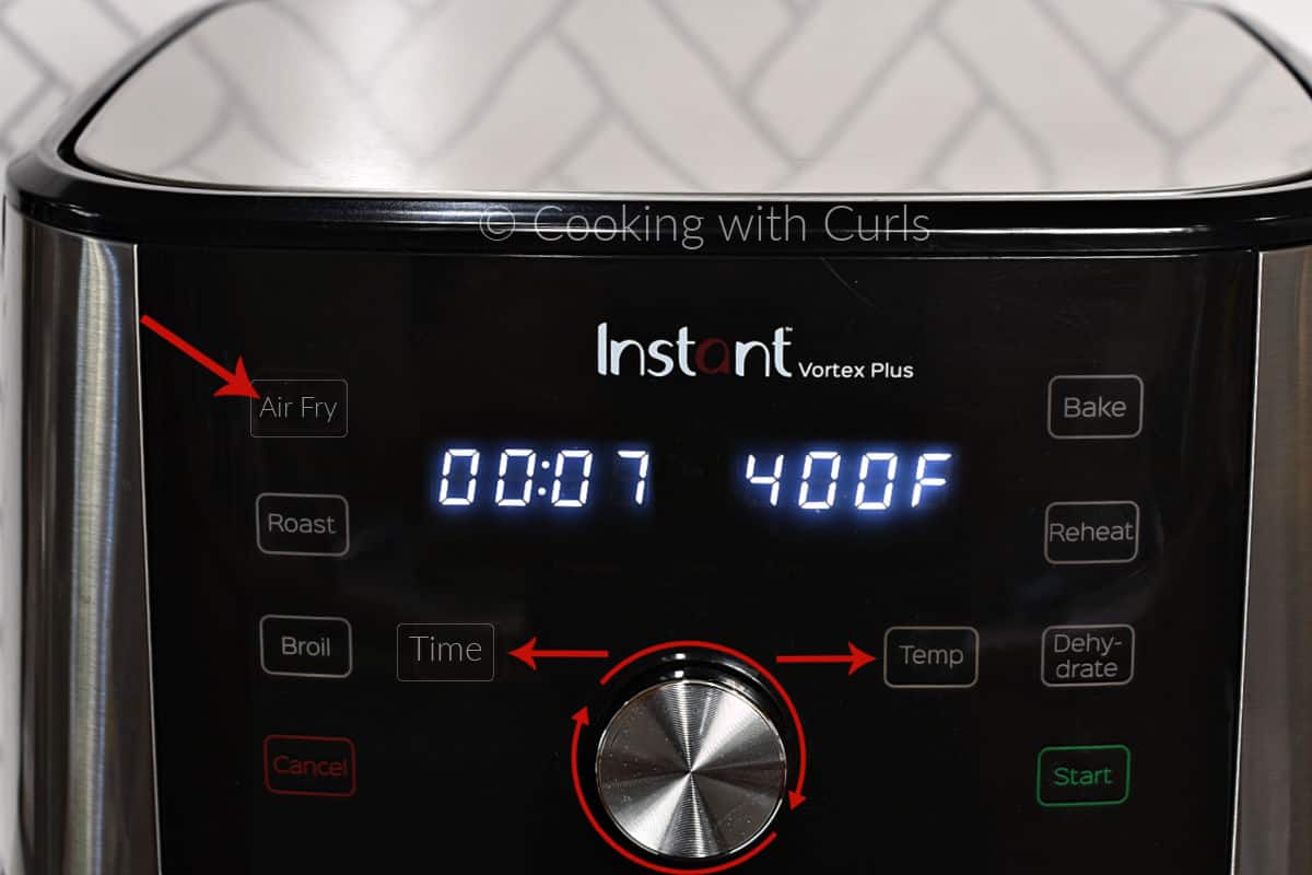 Air Fryer with arrows to Time and Temp and around the knob showing to turn to adjust. 