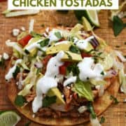 Crispy corn tortilla shell topped with beans, chicken, tomato, avocado, lettuce, and sour cream with title graphic across the top.