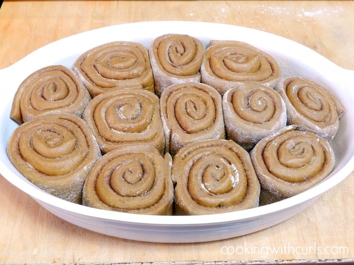 Gingerbread Cinnamon Rolls doubled in size in an oval baking dish.