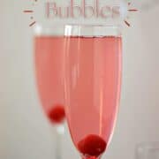 Two pink, sparkling cocktails with a cherry at the bottom of a champagne flute with title graphic across the top.