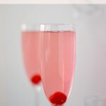 Kinky Bubbles Cocktail in a champagne flute with a cherry at the bottom