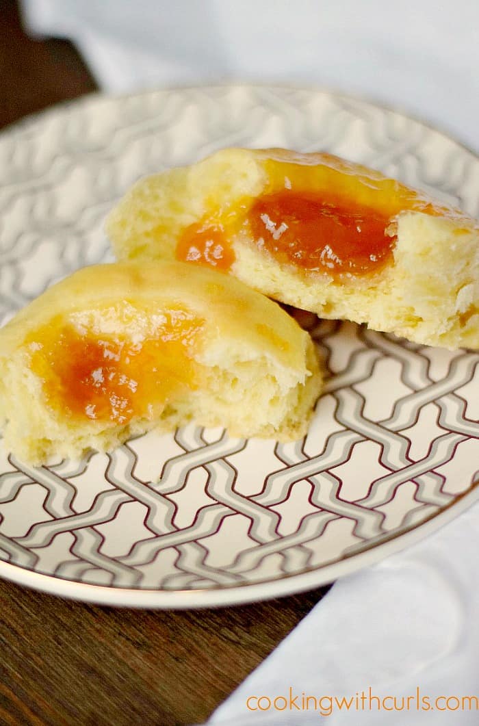 an apricot kolache broken apart and sitting on a gray and white zigzag patterned plate