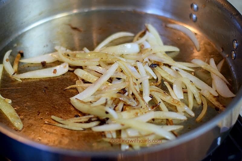 sliced onions in a large stainless steel skillet