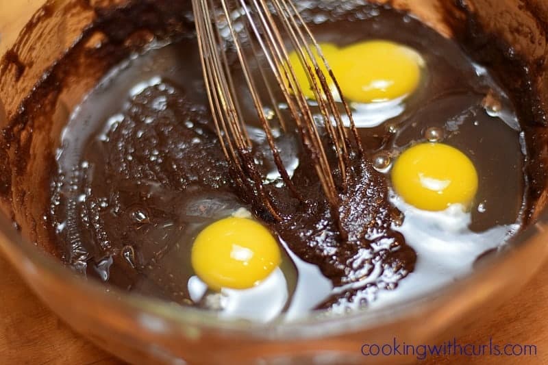 Four eggs broken on top of the chocolate mixture.