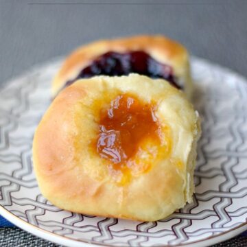 apricot and blueberry kolaches sitting on a gray and white zigzag plate