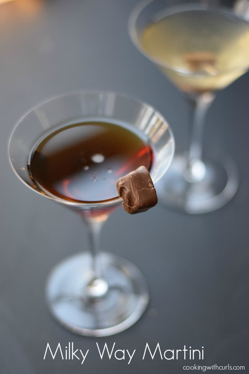 A dark Milky Way Martini garnished with a bite-sized candy bar on the rim.